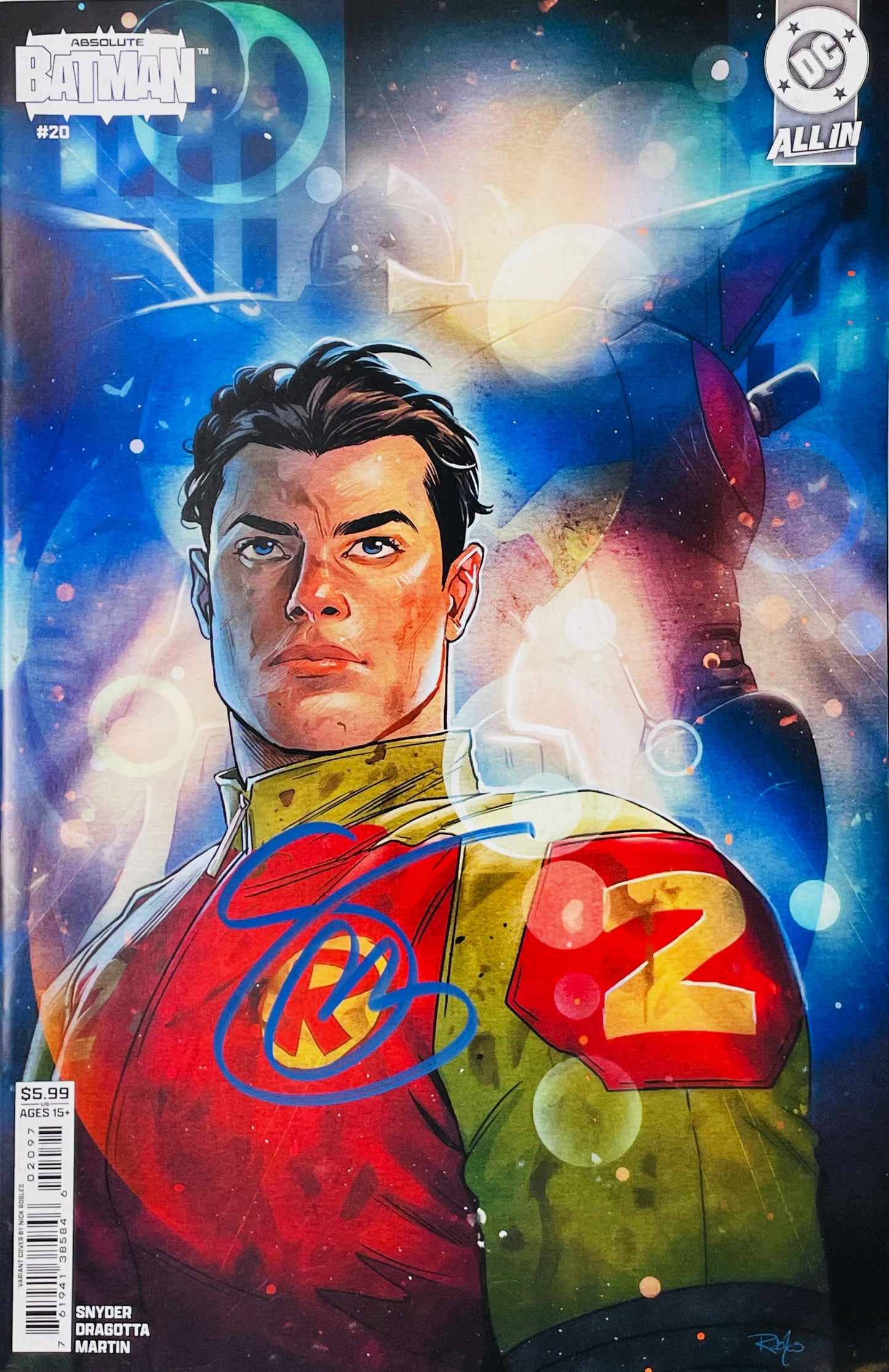 Signed Absolute Batman issue 20 variant cover by Nick Robles showing an unmasked Robin in a yellow and red suit with a blue paint pen signature over his emblem.