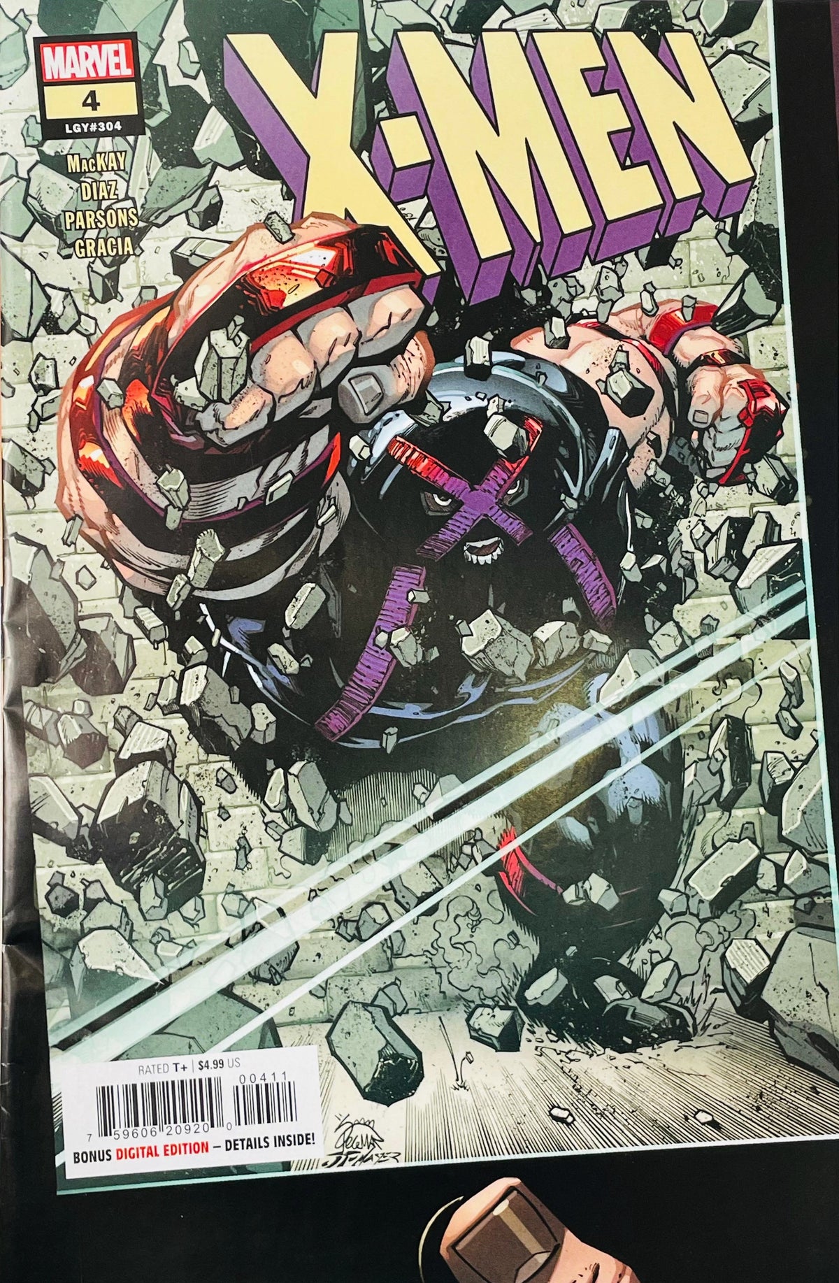 X-Men #4 Ryan Stegman comic book cover featuring Juggernaut in his armored helmet with a purple X bursting through shattered concrete and rubble, with Magik, Temper and other X-Men fighting around him beneath the large cream and purple X-Men logo.