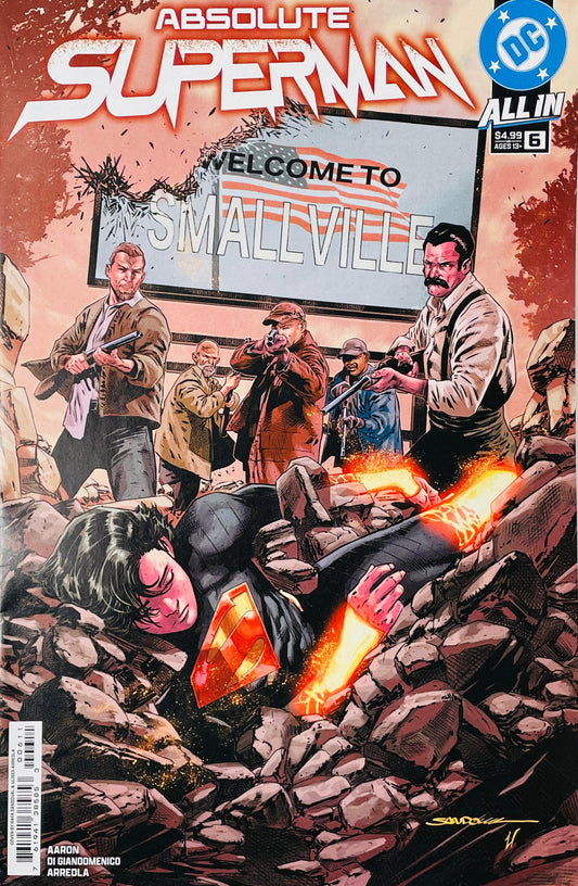 Absolute Superman issue 6 cover featuring a fallen, dark-suited Superman in stone rubble surrounded by armed townspeople under a Welcome to Smallville sign.