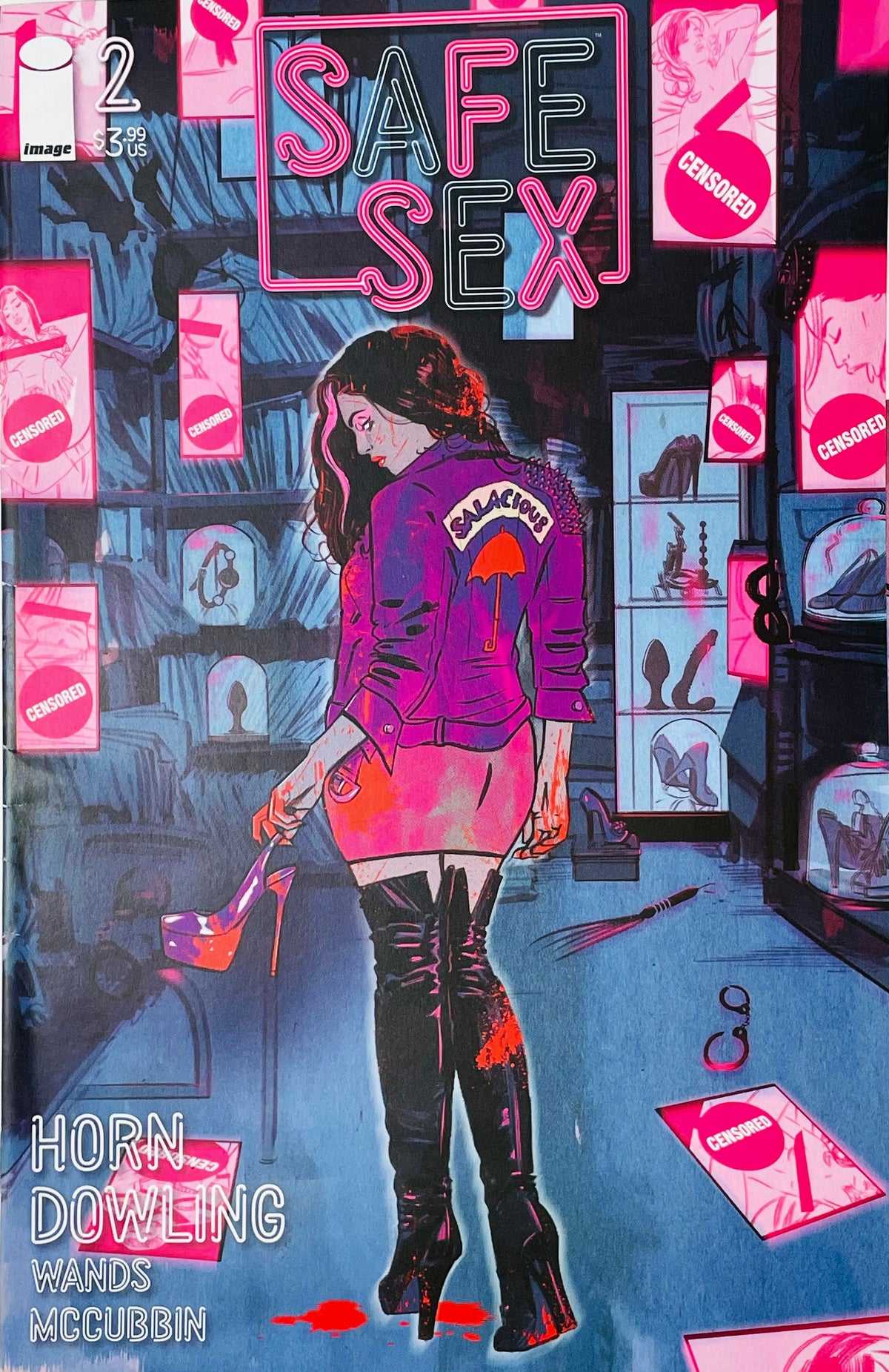 Safe Sex issue 2 cover by Michael Dowling featuring a woman in a purple jacket and thigh-high boots in a neon-lit room filled with censored photos.