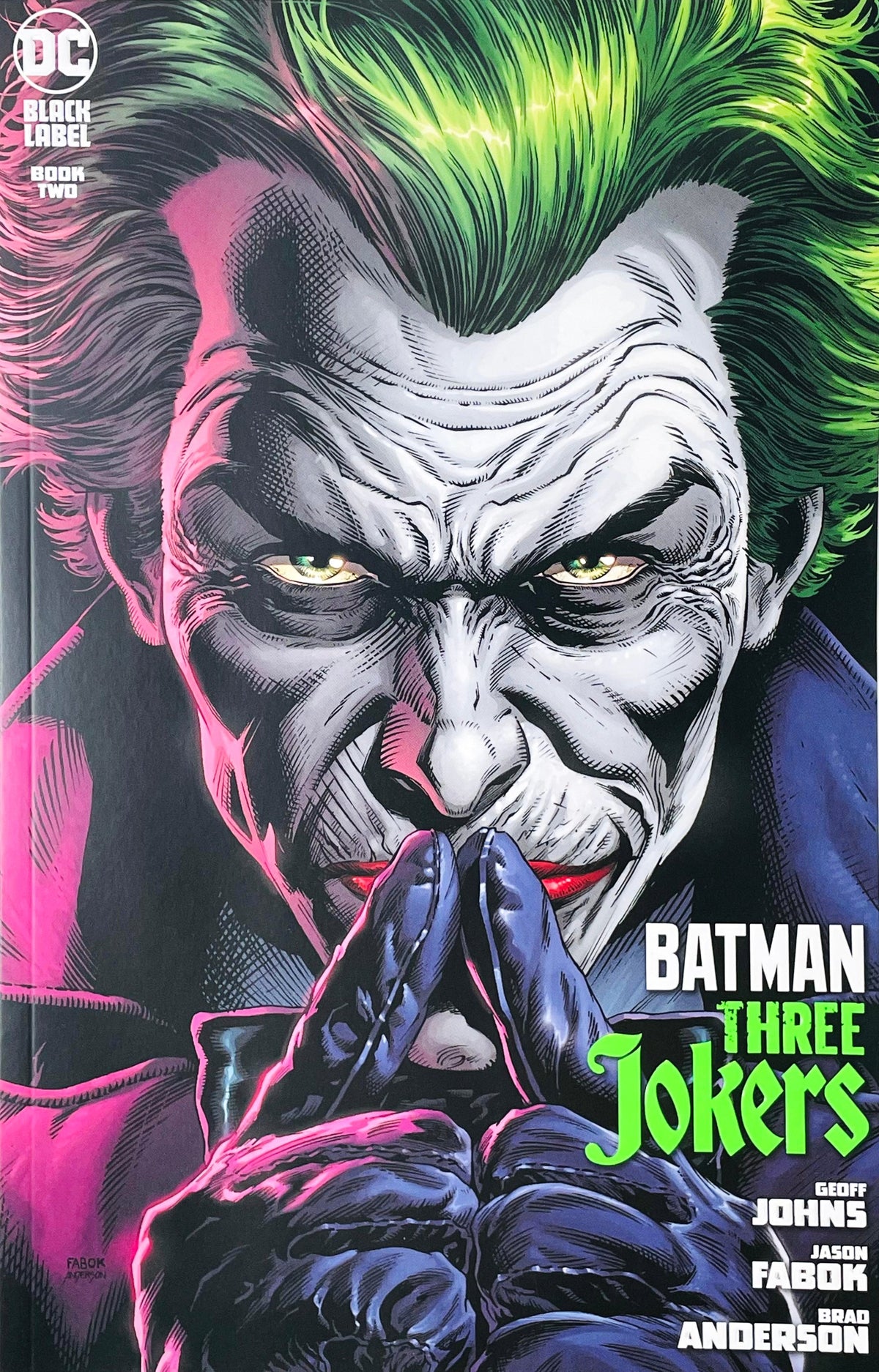 Batman Three Jokers issue 2 comic book published by DC Comics Black Label featuring Jason Fabok cover art of the Joker with gloved hands steepled in deep thought.