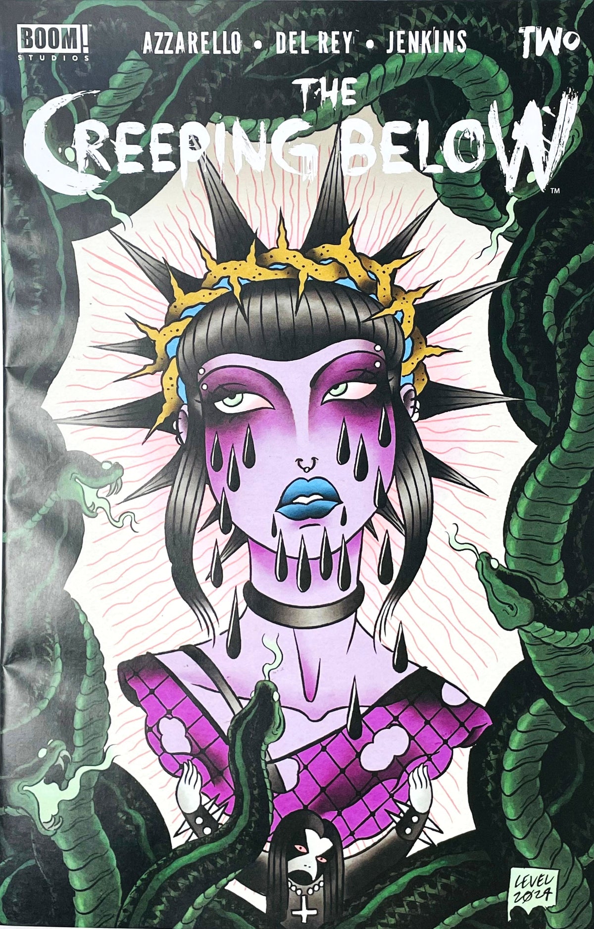 The Creeping Below issue 2 comic book published by BOOM Studios featuring Level cover art of a gothic purple-skinned woman surrounded by green serpents.