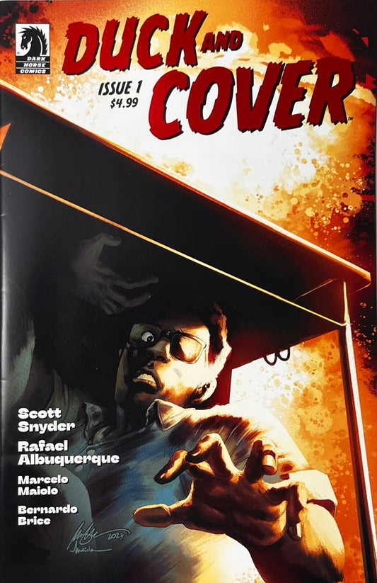 Duck and Cover issue 1 comic book published by Dark Horse Comics featuring Rafael Albuquerque cover art of a terrified man ducking under a desk during a nuclear blast.